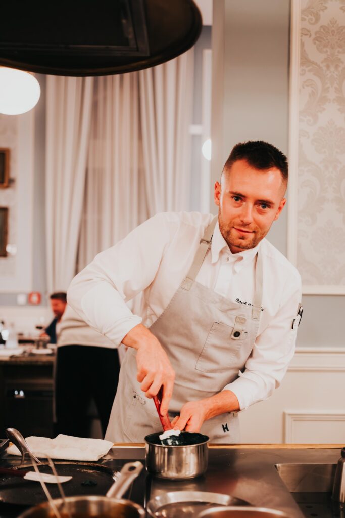 Kuchár pripravuje jedlo v kuchyni.