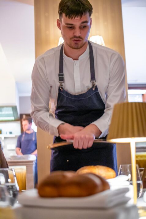 Čašník servíruje jedlo v reštaurácii.