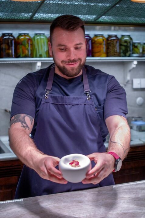 Kuchár podáva misku s jedlom.