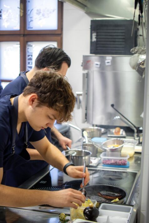 Kuchári pripravujú jedlo v kuchyni.