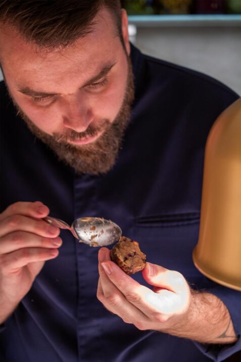 Muž drží lyžicu s jedlom.